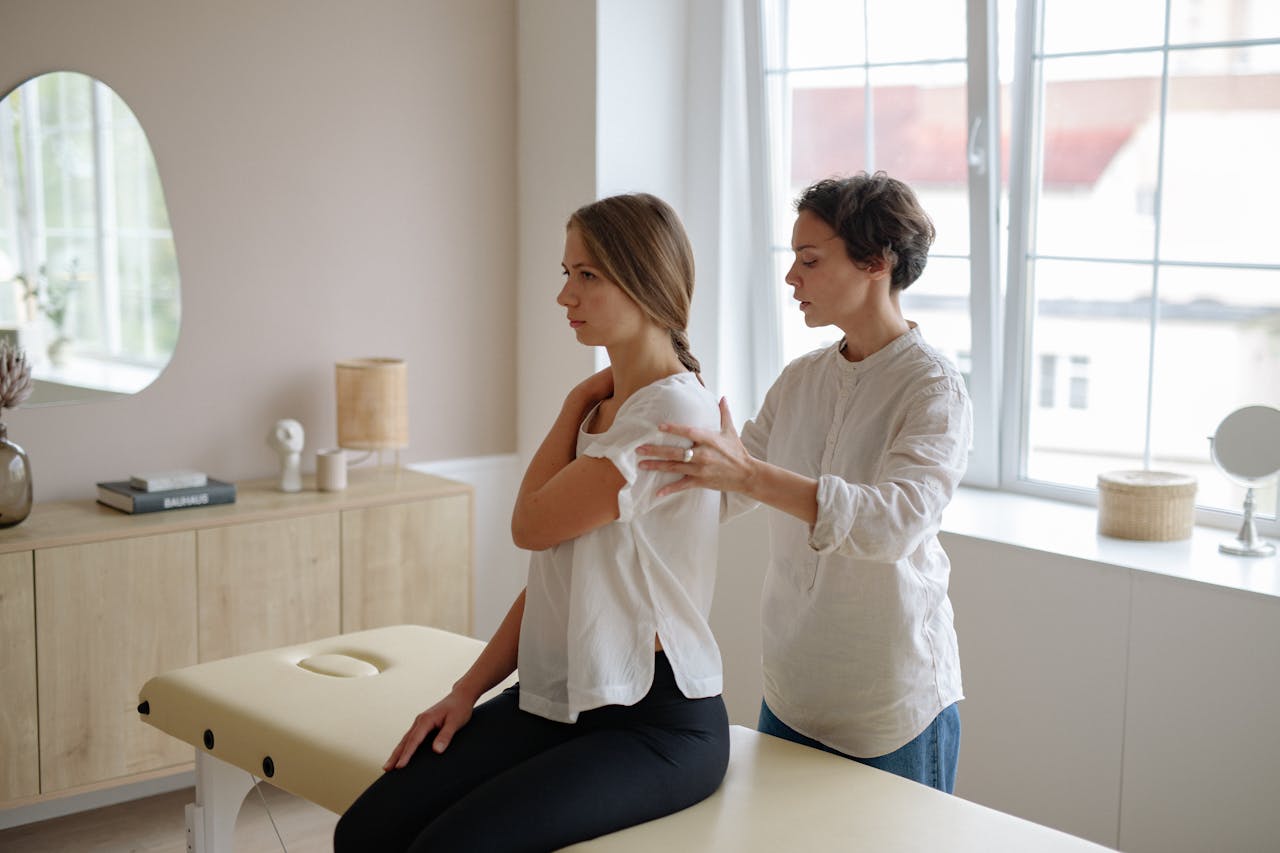 Crafting Captivating Headlines: Your awesome post title goes here A massage therapist providing shoulder treatment to a woman in a well-lit studio.